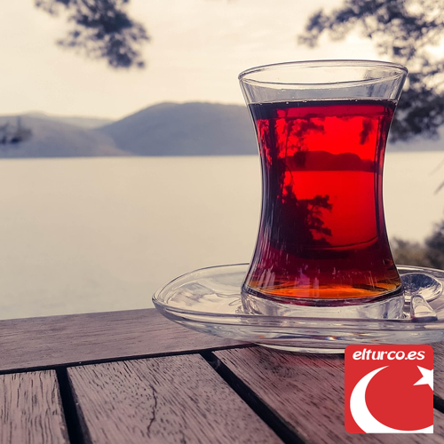 Té negro turco: Rize, Ceilán o Tomurcuk ¿cuál comprar? Vaso tulipán de té negro turco de un rojo intenso junto a un lago